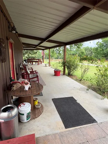 a view of a patio with a table chairs and a yard