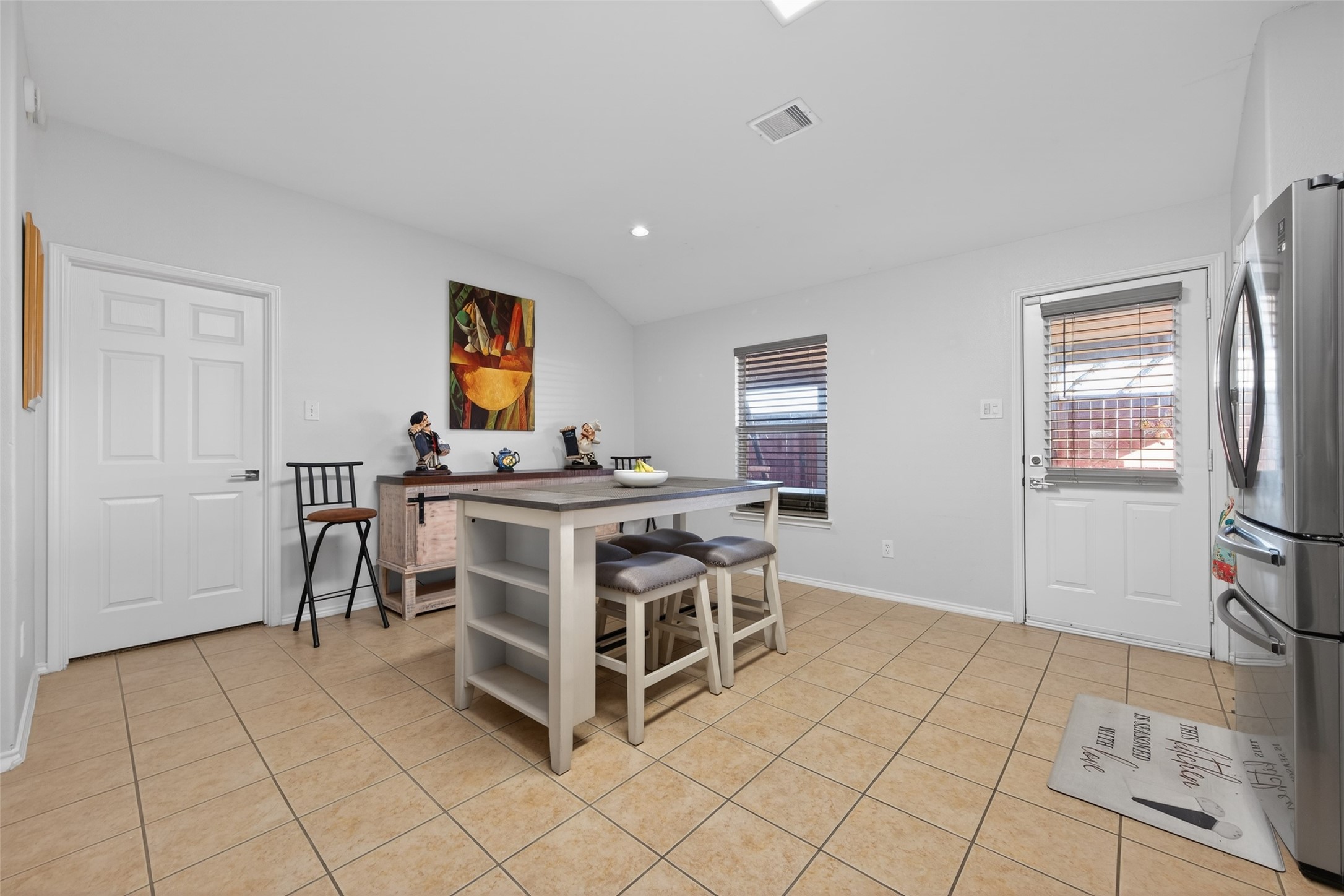 20218 Appaloosa Ridge Drive Humble, TX 77338 - Photo 23 of 44 Bright, spacious kitchen with tile flooring, modern appliances, and a central island with seating. Features a door leading outside and a large window for natural light.