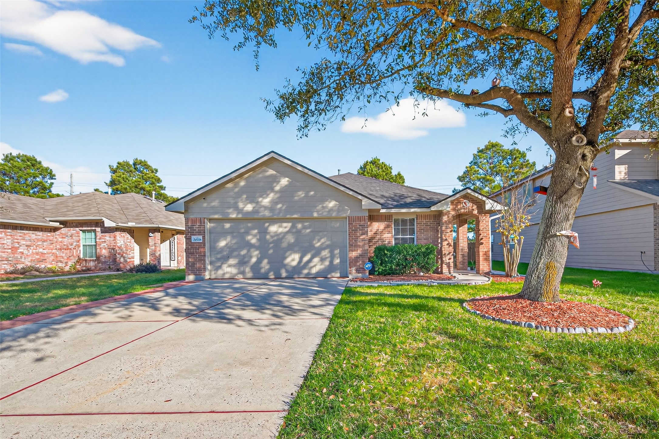 20218 Appaloosa Ridge Drive Humble, TX 77338 - Photo 3 of 44 Charming single-story brick home with a neatly manicured front yard, featuring a large tree and attractive landscaping. The house has a two-car garage, a welcoming front entrance, and is set in a quiet neighborhood.