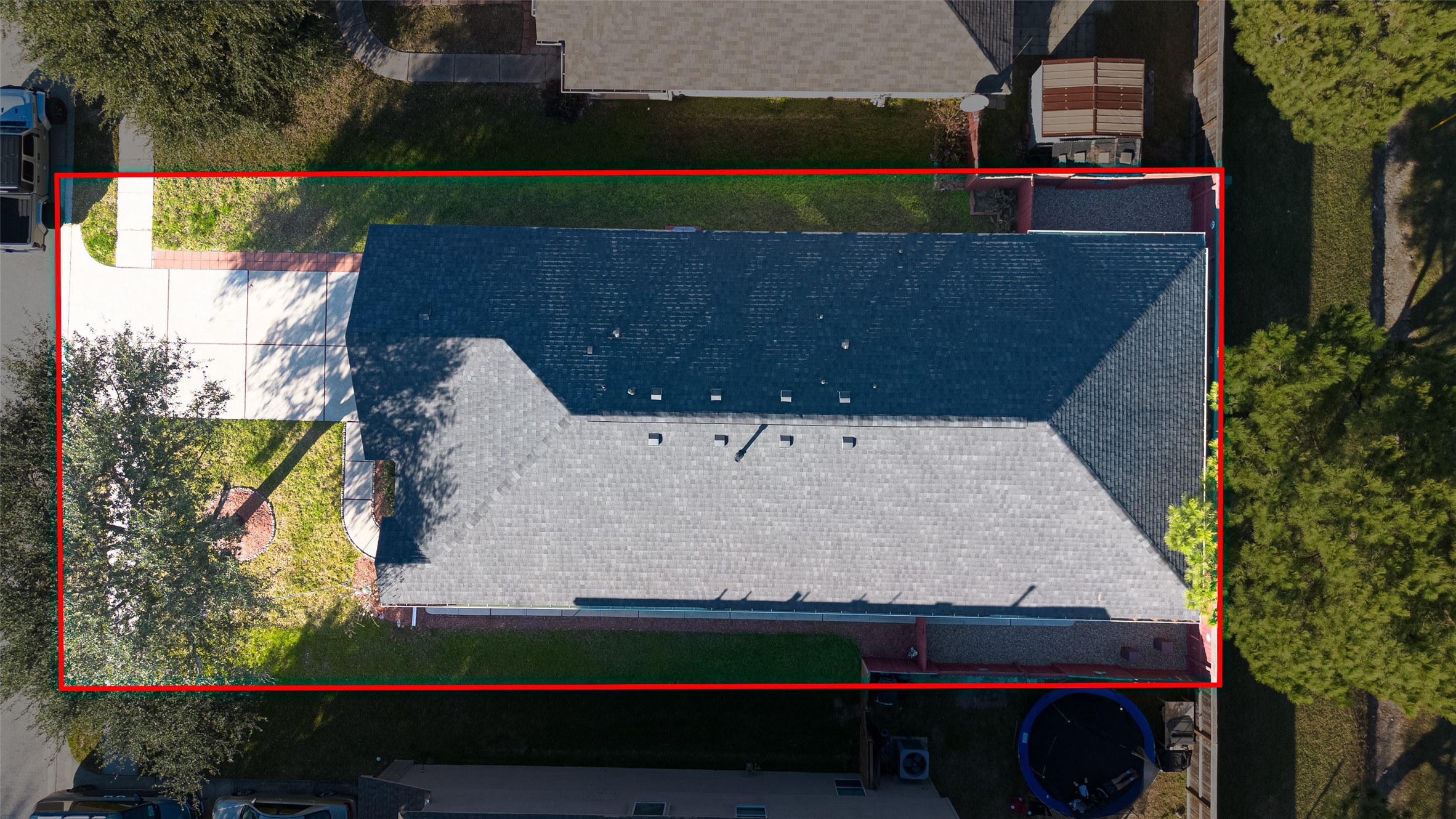 20218 Appaloosa Ridge Drive Humble, TX 77338 - Photo 41 of 44 This aerial photo shows a house with a gray roof, a driveway, and a small front yard with trees. The property is outlined in red, indicating its boundaries.