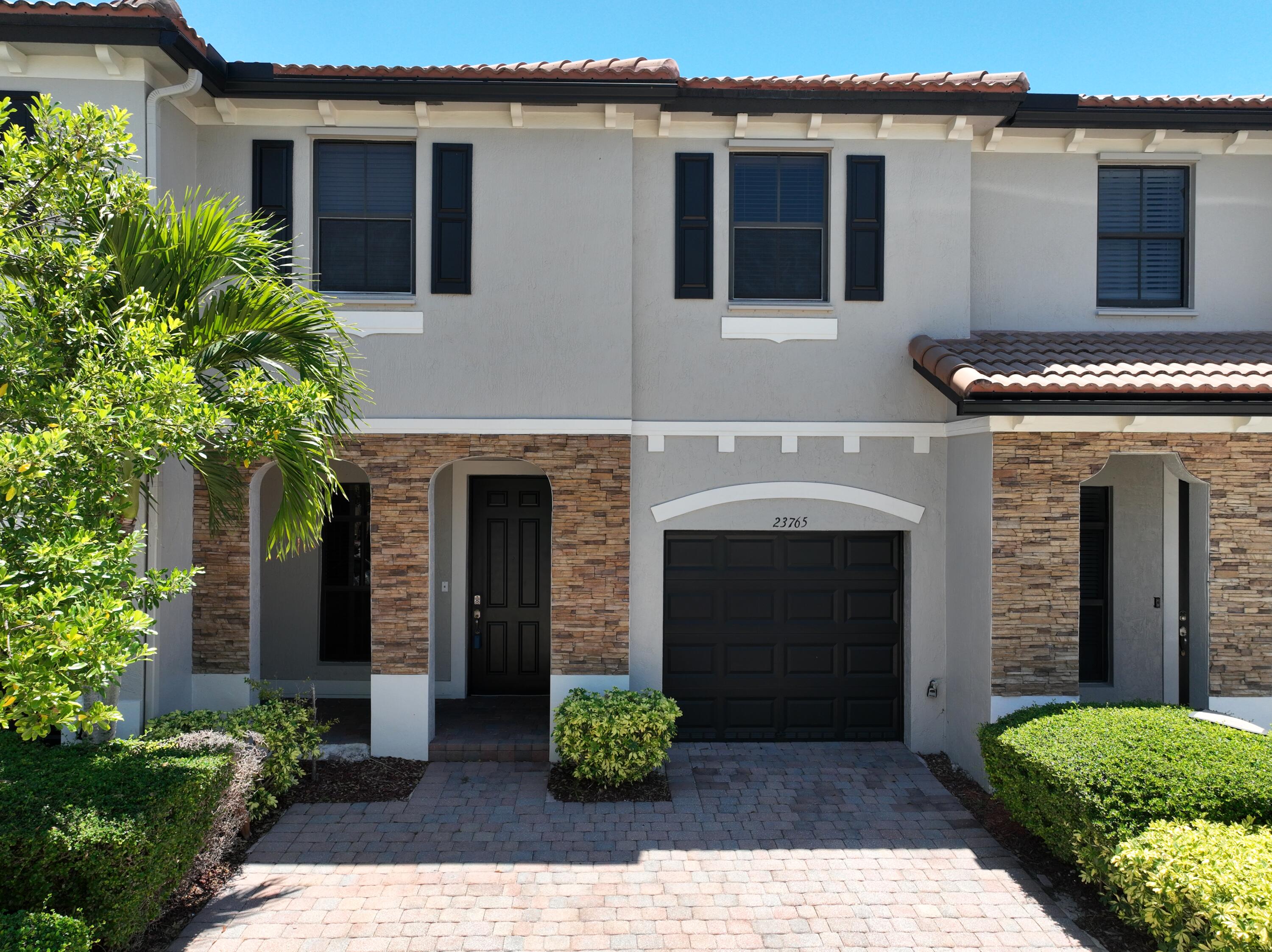 23765 Southwest 118 Avenue, Unit 23765 Homestead, FL 33032 - Photo 2 of 36 a front view of a house with a garden