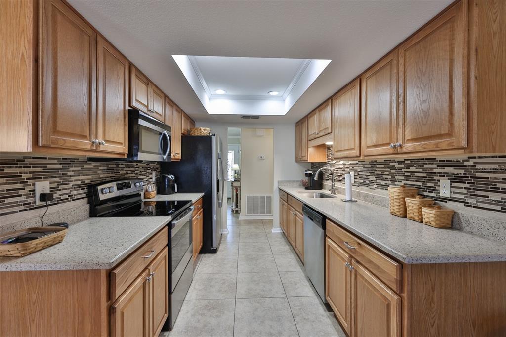 1806 Wedge Court Sun City Center, FL 33573 - Photo 20 of 53 a kitchen with stainless steel appliances granite countertop a sink stove microwave refrigerator and cabinets