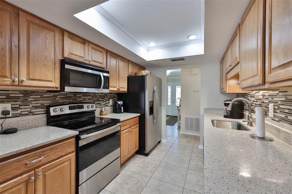 1806 Wedge Court Sun City Center, FL 33573 - Photo 21 of 53 a kitchen with granite countertop a stove sink and refrigerator