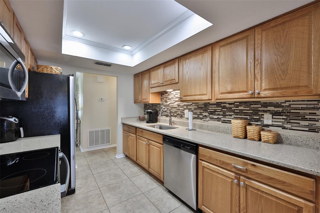1806 Wedge Court Sun City Center, FL 33573 - Photo 22 of 53 a kitchen with stainless steel appliances granite countertop a sink stove and cabinets