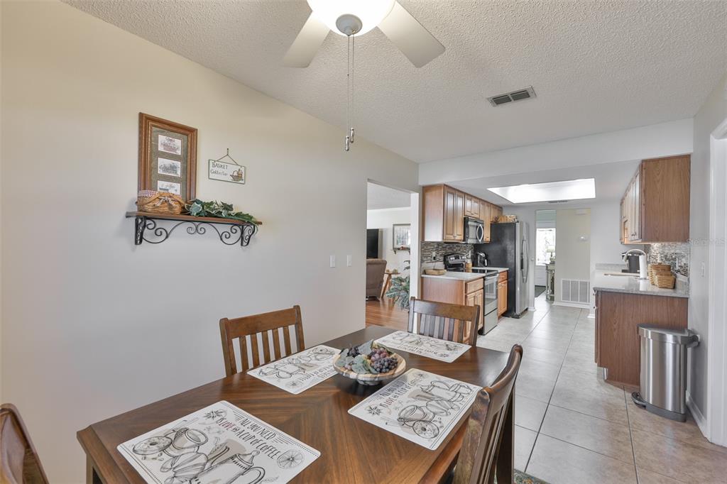 1806 Wedge Court Sun City Center, FL 33573 - Photo 24 of 53 a living room with furniture a rug kitchen view and a chandelier