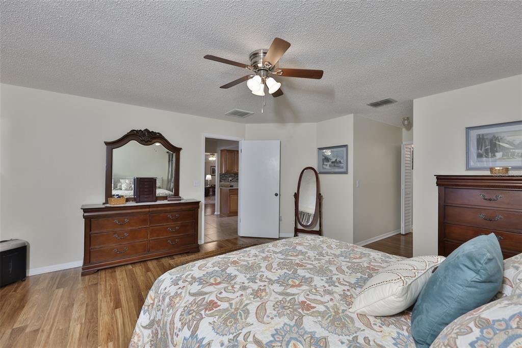 1806 Wedge Court Sun City Center, FL 33573 - Photo 28 of 53 a bedroom with a bed and a dresser with mirror