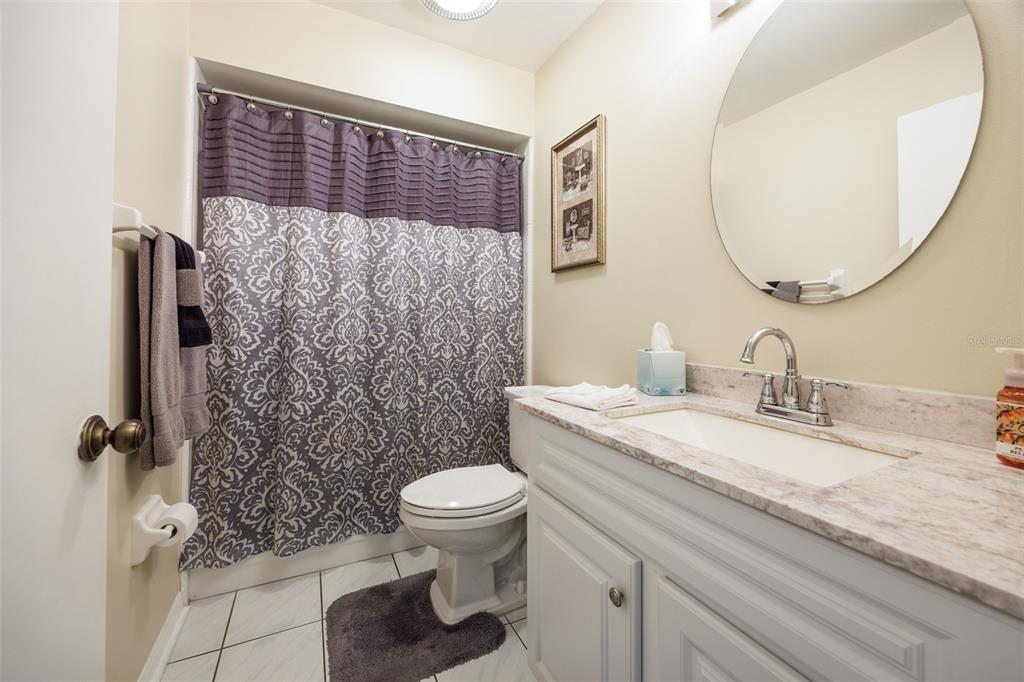 1806 Wedge Court Sun City Center, FL 33573 - Photo 34 of 53 a bathroom with a granite countertop toilet sink and mirror