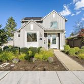 a front view of a house with a yard and potted plants
