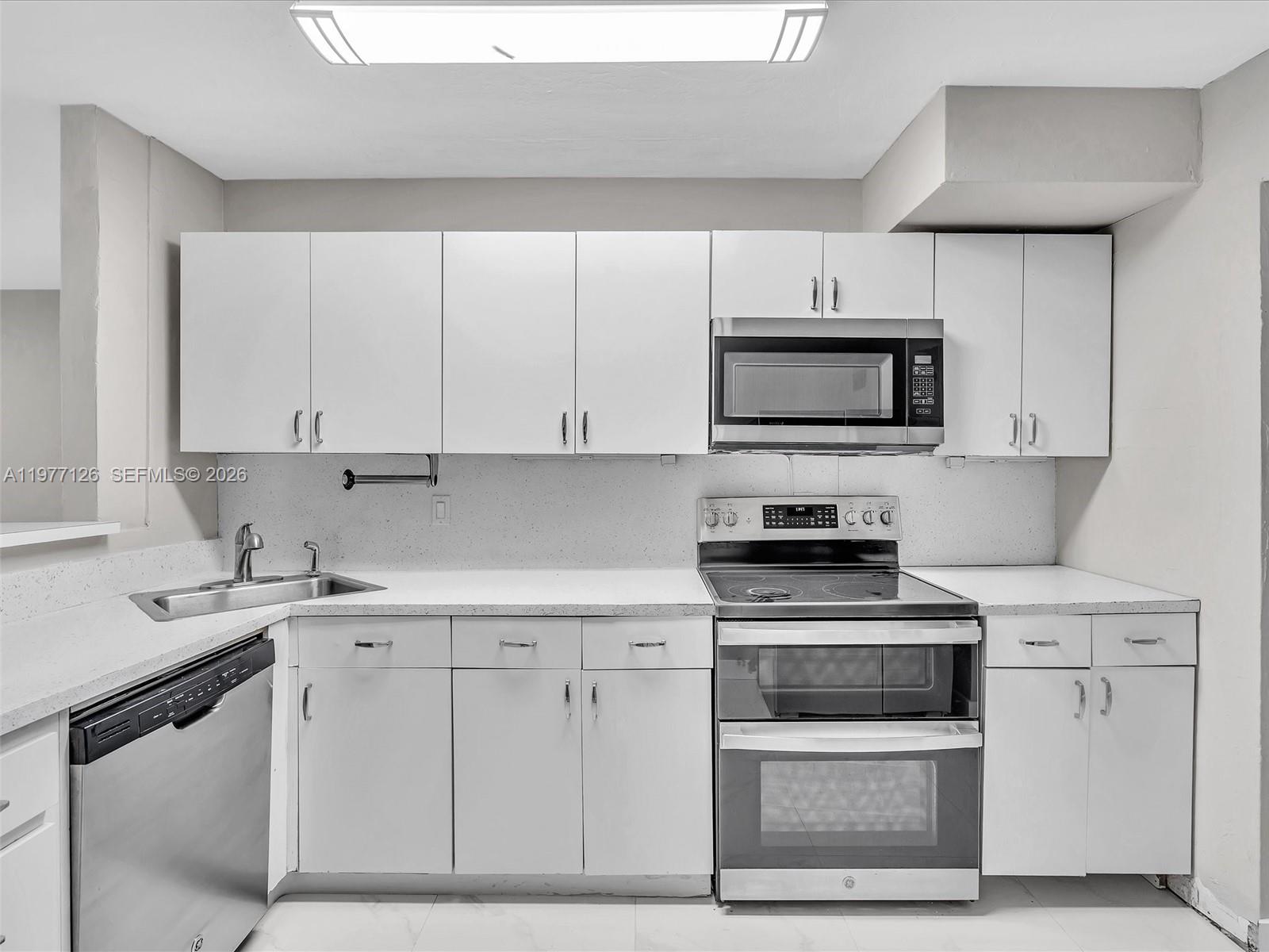 6800 Raleigh Street Hollywood, FL 33024 - Photo 18 of 42 a kitchen with white cabinets and stainless steel appliances