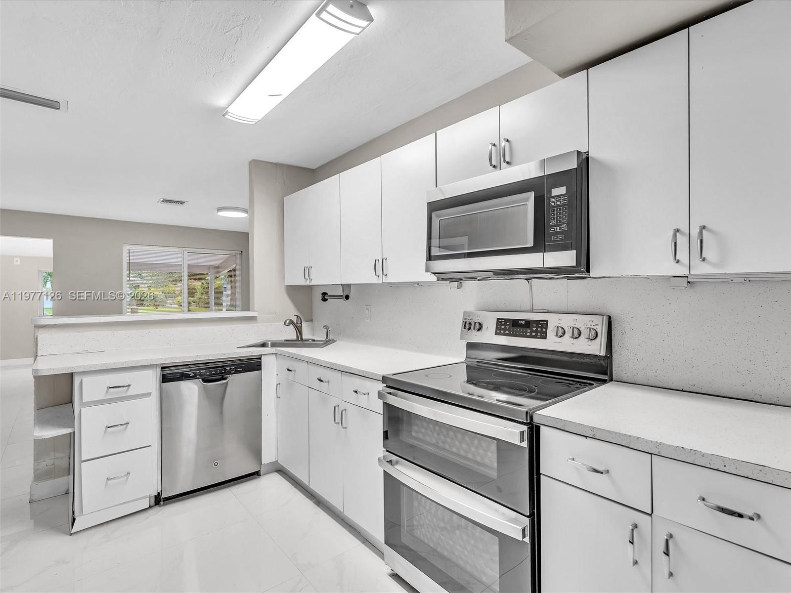 6800 Raleigh Street Hollywood, FL 33024 - Photo 19 of 42 a kitchen with cabinets stainless steel appliances and a window