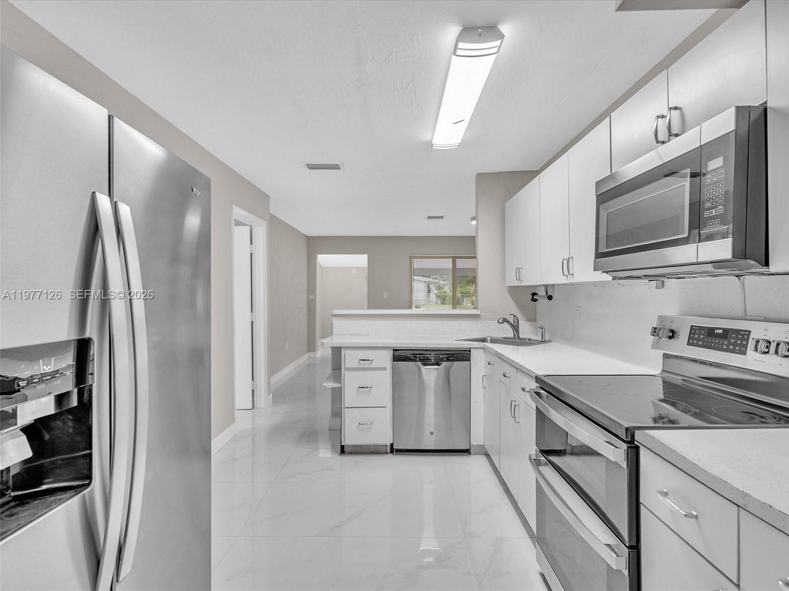 6800 Raleigh Street Hollywood, FL 33024 - Photo 20 of 42 a kitchen with a sink stove and refrigerator