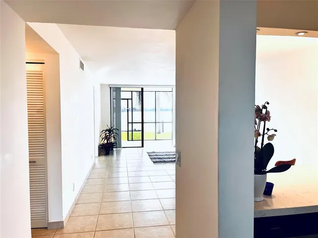 a hallway with a large window and a potted plant