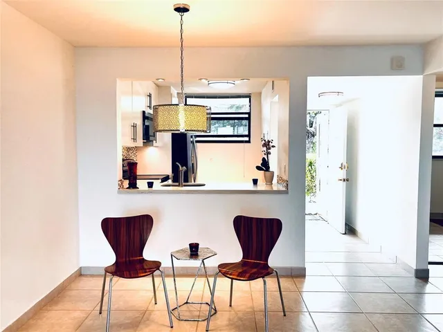 a kitchen with a refrigerator a stove and a chair