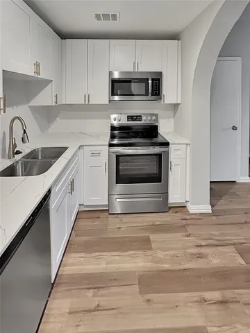 a kitchen with stainless steel appliances kitchen island granite countertop a stove top oven and sink