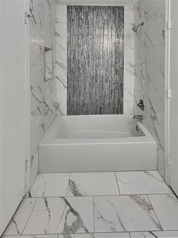 a bathroom with a bathtub and shower