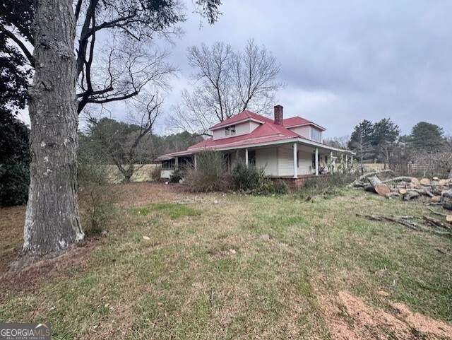 a view of a house with a yard and sitting area