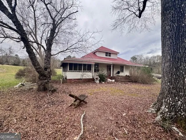a view of a house with backyard and trees