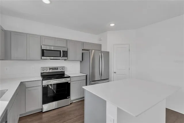 a kitchen with stainless steel appliances a refrigerator stove and microwave