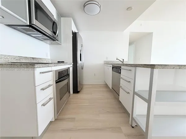 a kitchen with white cabinets and white appliances