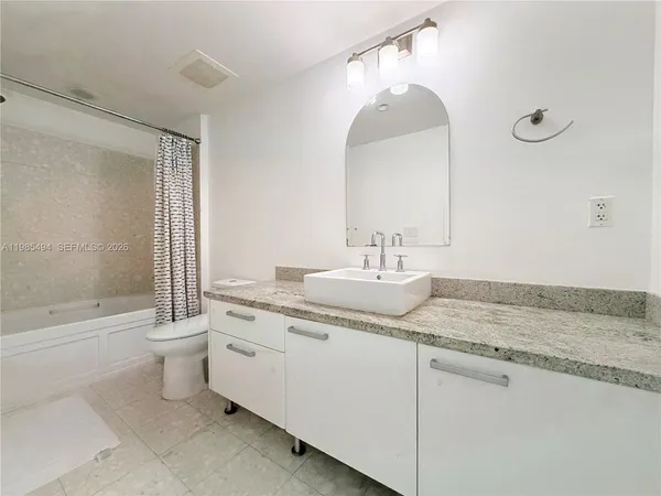 a bathroom with a granite countertop sink a toilet and a bathtub