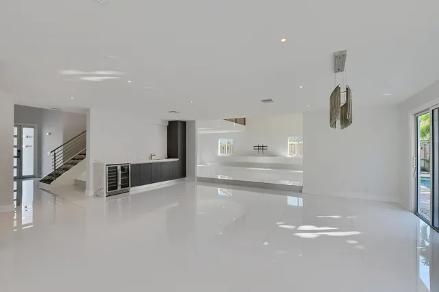 a large white kitchen with stainless steel appliances a large counter top