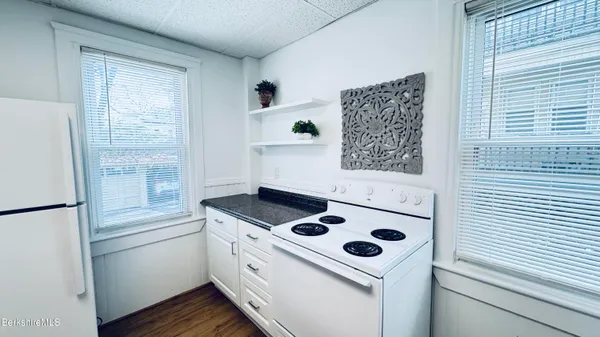 a white stove top oven sitting inside of a kitchen