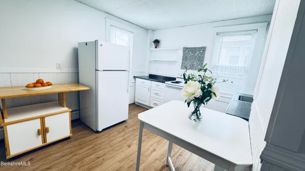 a kitchen with stainless steel appliances a refrigerator sink and wooden floor