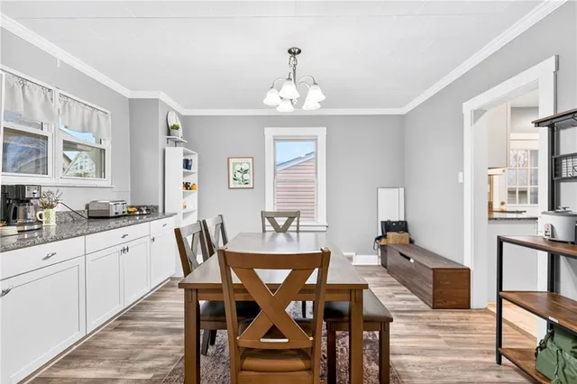a view of a dining room with furniture a chandelier and wooden floor