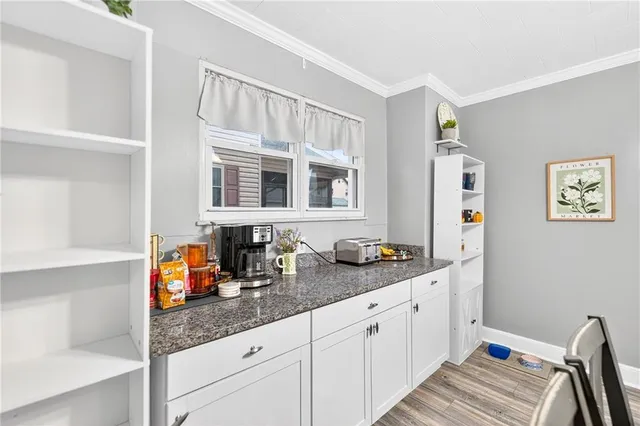 a dining room with wooden floor a chandelier a wooden table and chairs