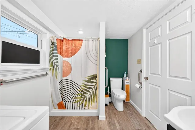 a bathroom with a toilet sink vanity granite tub and mirror