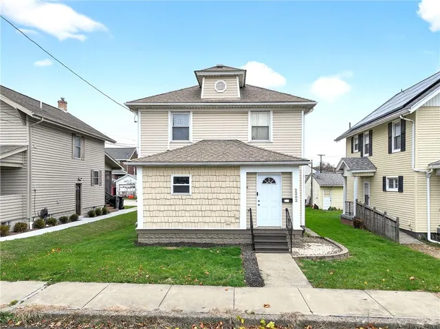 a view of a white house with a small yard and a large window