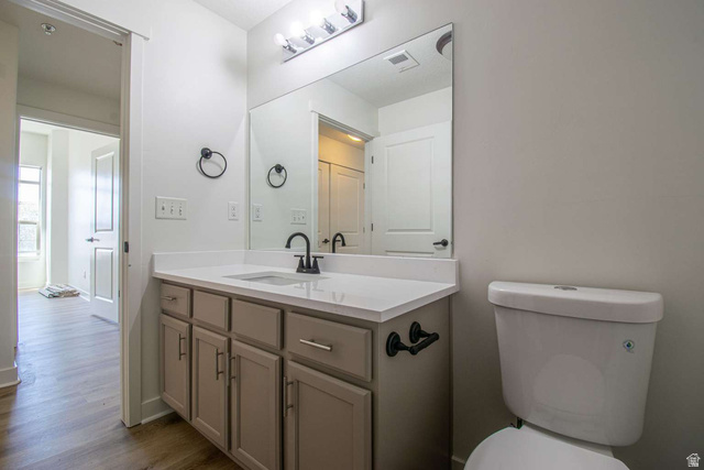 4276 South Main Street, Unit 303 Murray, UT 84107 - Photo 10 of 20 Bathroom vanity featuring light-toned cabinetry with dark hardware, a white countertop, and a rectangular undermount sink with a matte black faucet