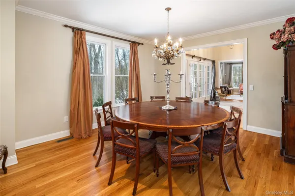 a dining room with furniture a chandelier and wooden floor