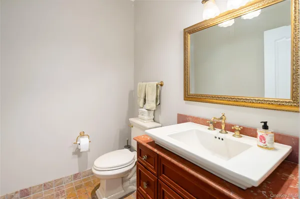 a bathroom with a sink a toilet and mirror
