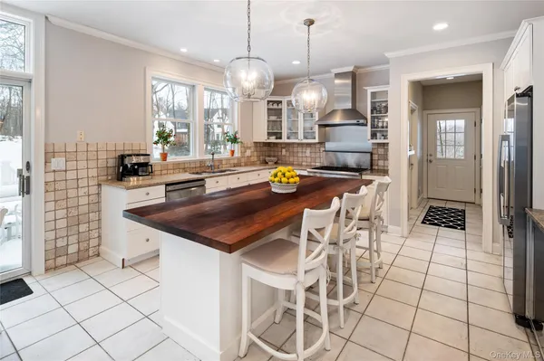 a kitchen with stainless steel appliances kitchen island granite countertop a stove a sink and a cabinets