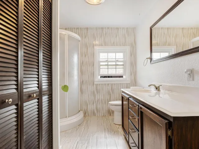 a bedroom with a large bed chandelier and a window