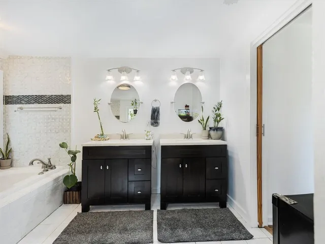 a spacious bedroom with a bed and wooden floor