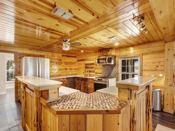 a kitchen with stainless steel appliances wooden floors and wooden cabinets