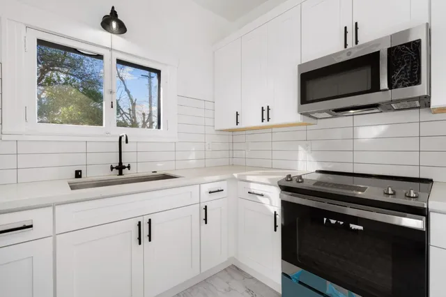 a kitchen with a sink stove and microwave