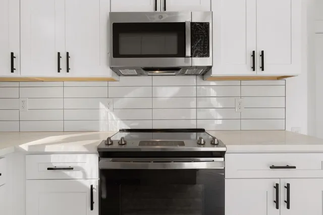 a stove top oven sitting inside of a kitchen
