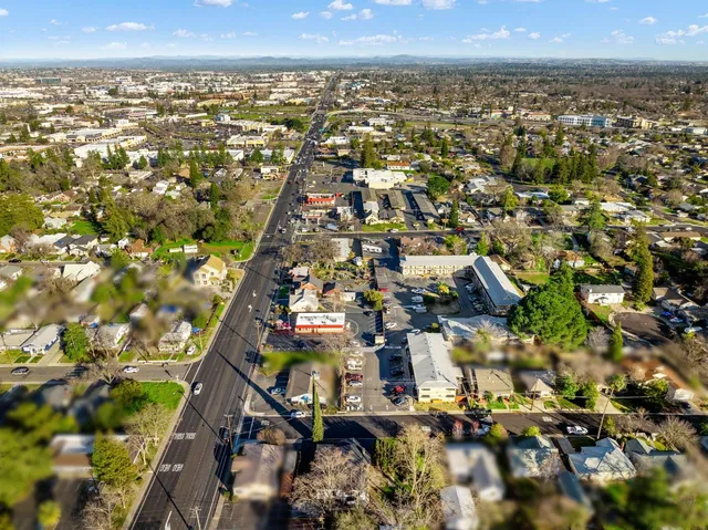 an aerial view of residential houses with outdoor space and trees
