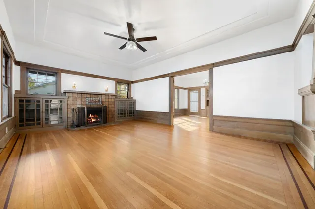 a view of empty room with fireplace and wooden floor