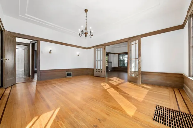 a big room with wooden floor and chandelier
