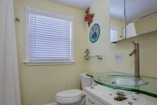 a bathroom with a sink a toilet and a window