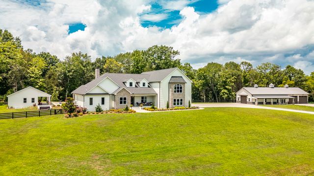 a view of a white house with a large window and yard