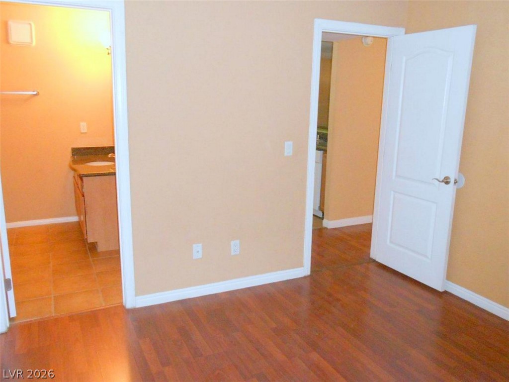 9325 West Desert Inn Road, Unit 132 Las Vegas, NV 89117 - Photo 16 of 36 Rich hardwood floors welcome you, with convenient access to the adjoining tiled bathroom.