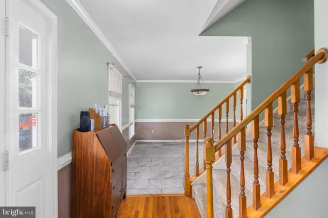 a view of staircase with railing and white walls