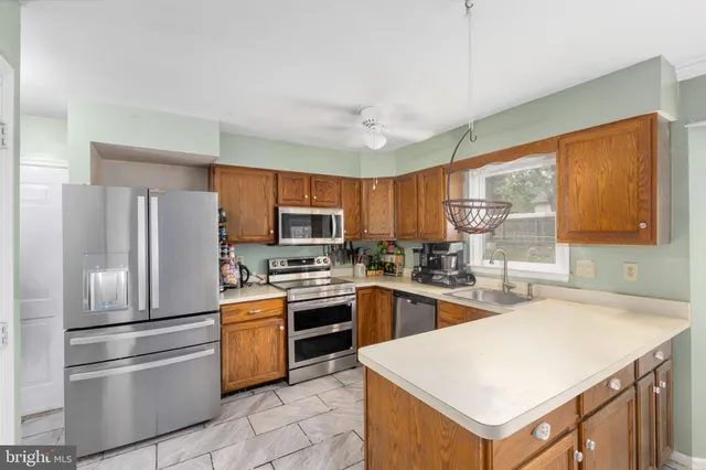 a view of an empty room with window and chandelier fan