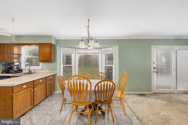 a view of a kitchen with a sink wooden floor and a chandelier