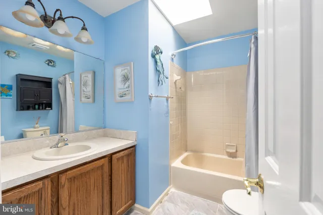 a bedroom with a bed lamp and a large window